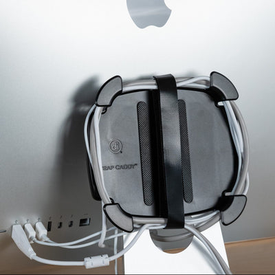 Photo of a Wrap Caddy with cords wrapped around it and attached to the back of an iMac.
