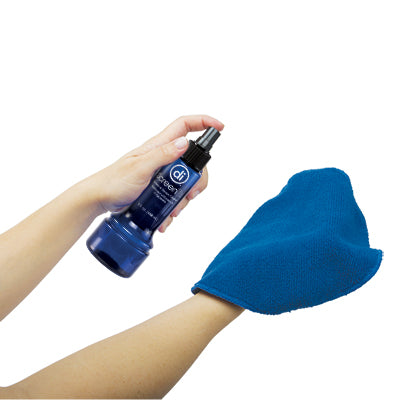 Photo of a pair of hands holding and spraying the ScreenDr solution on to a blue microfiber cloth.