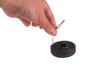 Photo of a hand demonstrating how to pull a pair of earbuds from a black Nest.