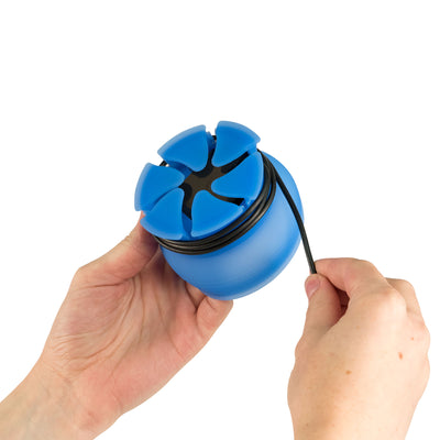 Photo of two hands demonstrating how to wrap a cord around a blue NestXL.